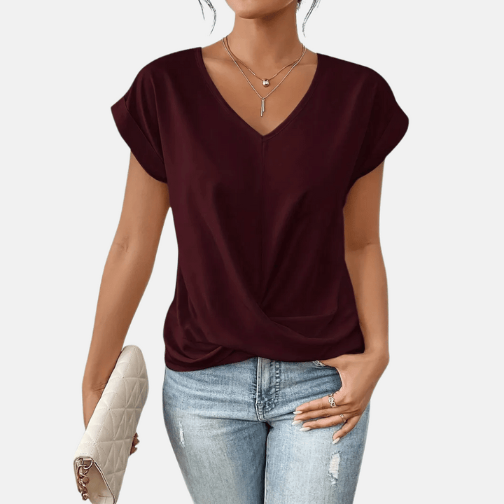 Chic women's short sleeve V-neck blouse with a unique draped hem, offering elegant & comfortable wear.