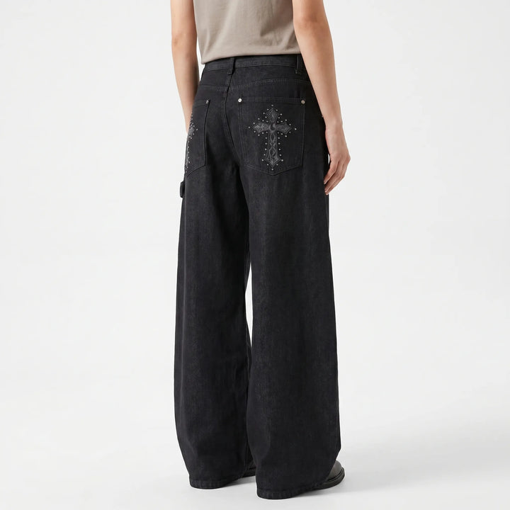 Women's low-rise wide-leg baggy pants with punk rock studded cross detail. Comfortable alternative style.