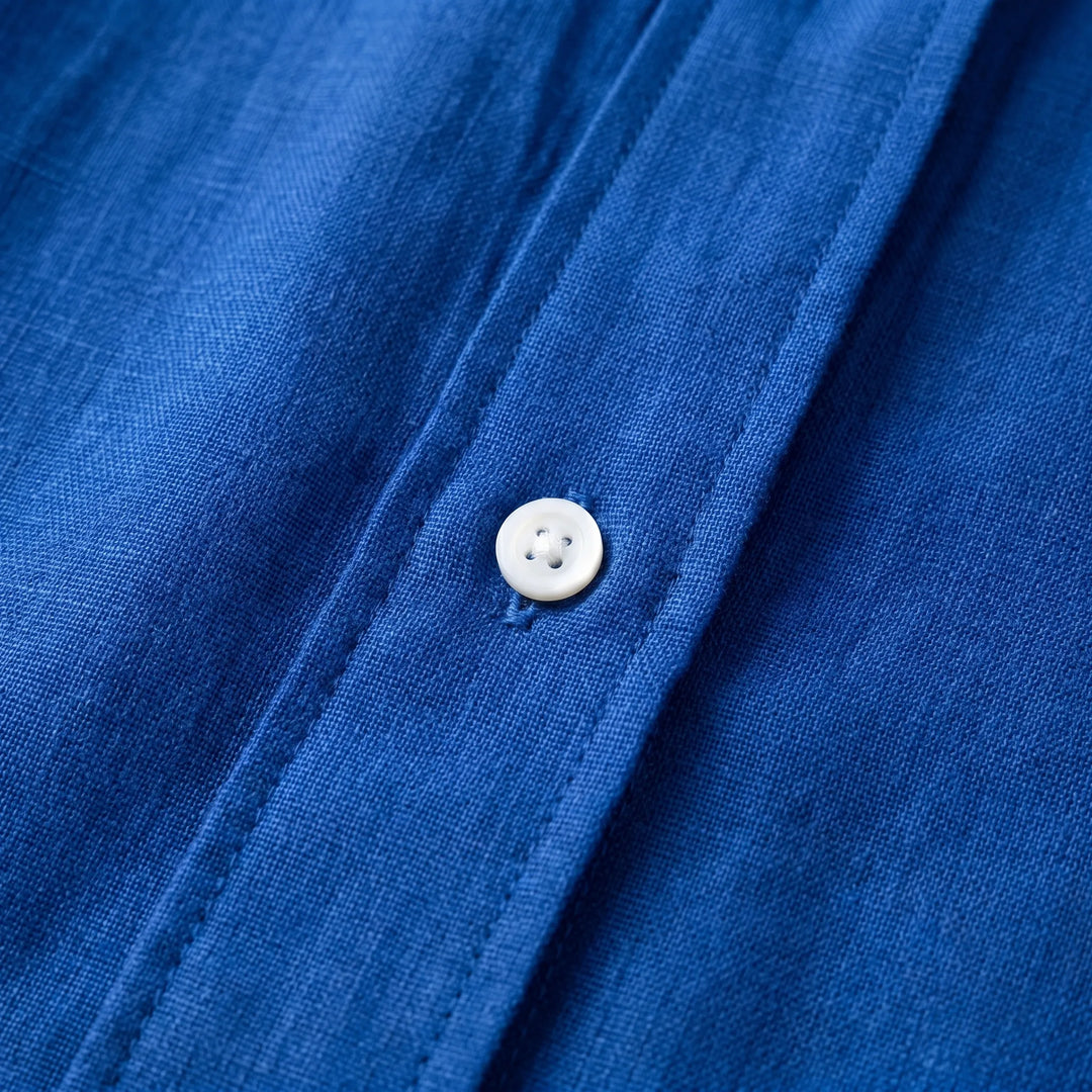 White oversized women's summer blouse with button-up detail, a lightweight, long sleeve casual top for warm weather.