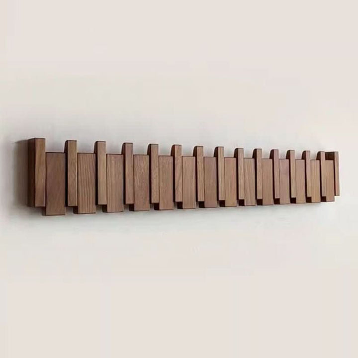 Elegant piano style wall coat rack with foldable hooks for entryway organization.