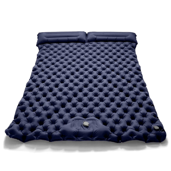Person inflating dual camping air bed with integrated pump. Quick, easy setup for comfortable portable sleep.