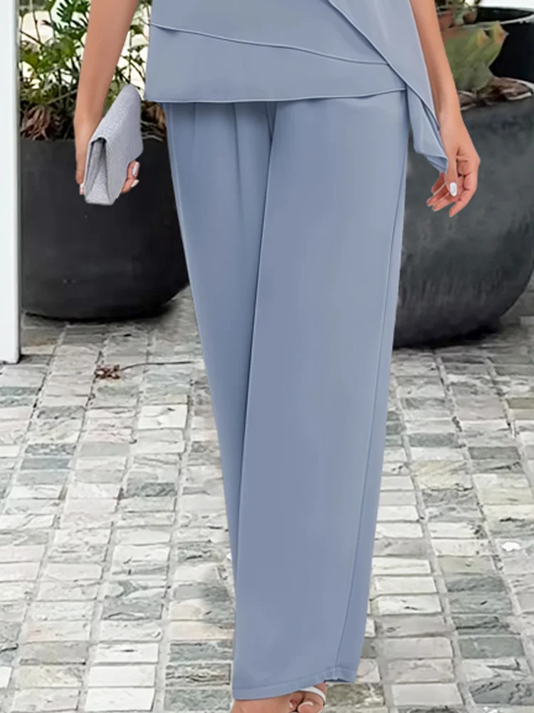 Women's elegant light blue asymmetrical top and matching wide-leg pants set. A comfortable and chic evening outfit.