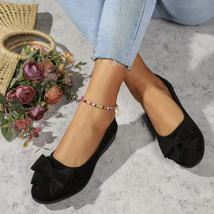 Elegant women's footwear: slip-on wedge heels adorned with a sophisticated bow.