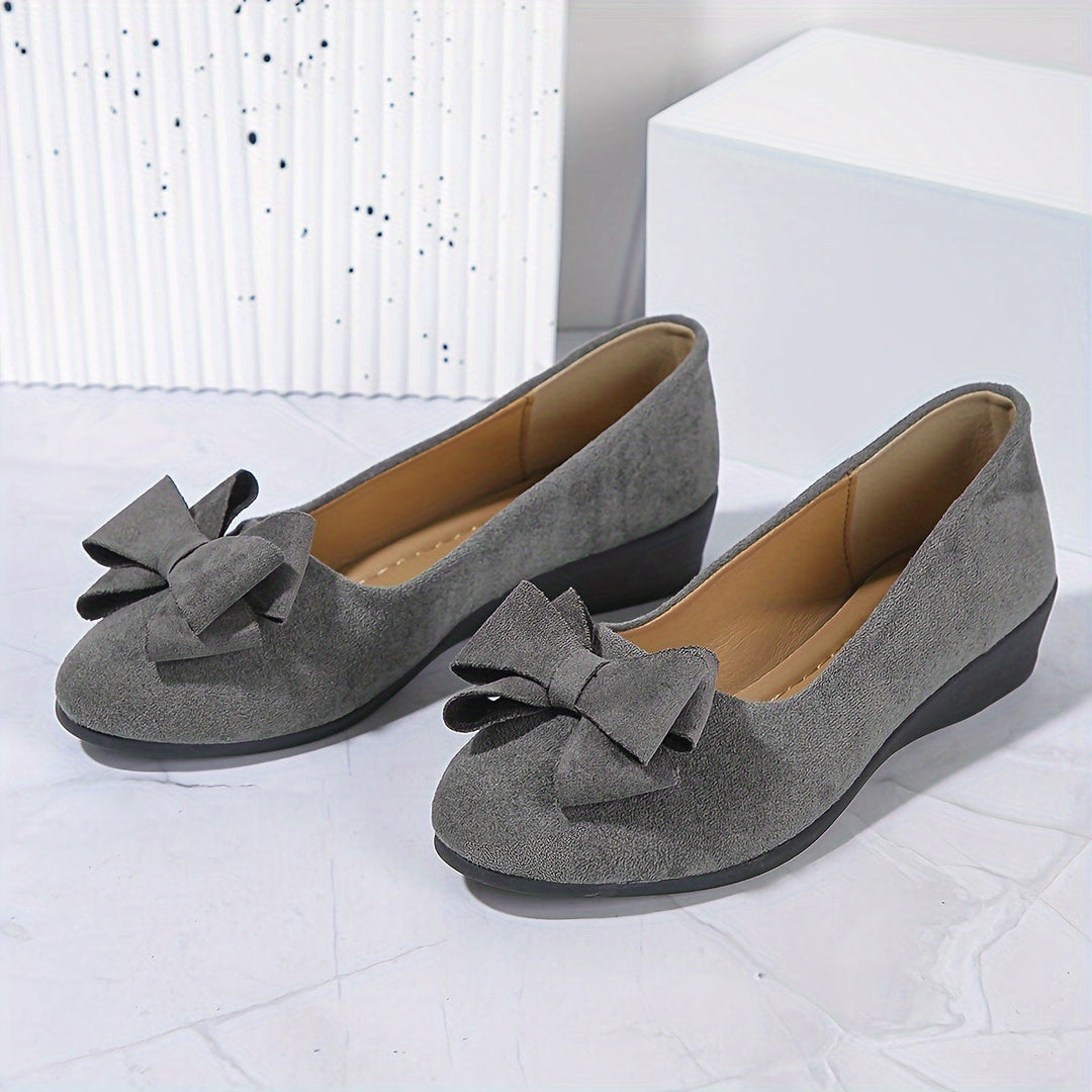 Versatile women's slip-on wedges with an eye-catching bow, combining comfort and style.
