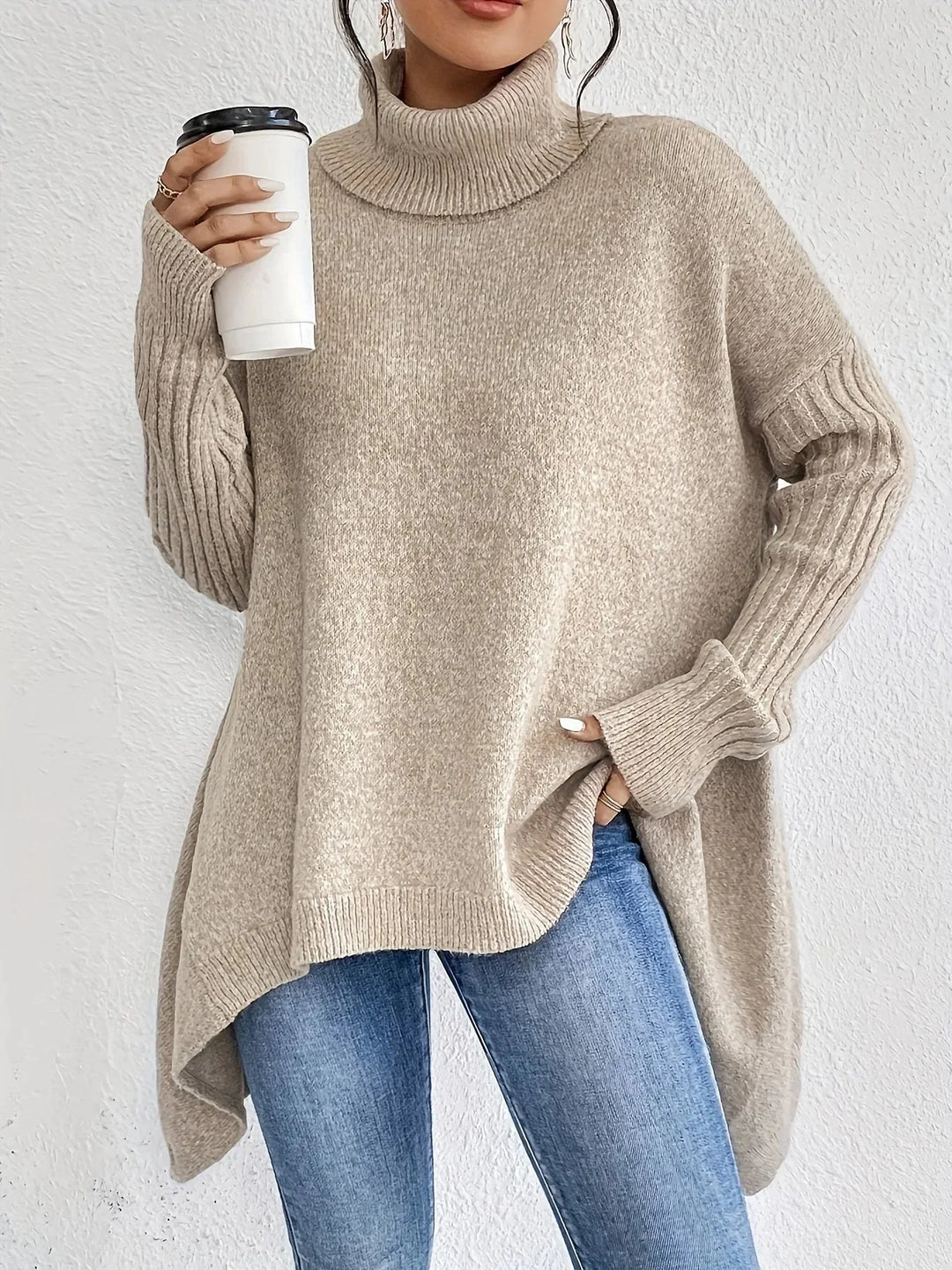 Close-up of a women's black asymmetrical turtleneck sweater, showing knit detail.