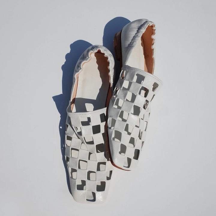 Top-down shot of women's elegant checkered leather flats, highlighting their comfortable slip-on style.