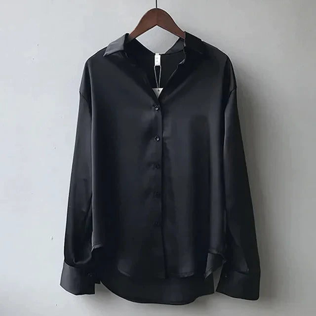 Close-up of a women's long sleeve button-down satin blouse, highlighting the luxurious texture and button details.
