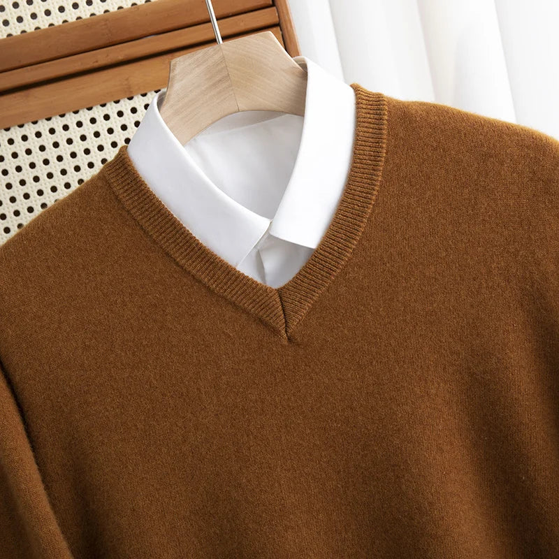 A stack of colorful men's merino wool V-neck sweaters in red, blue, and green for winter fashion