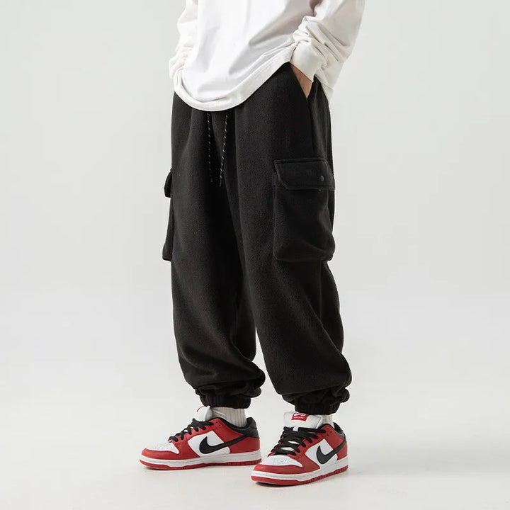 Men's cozy black fleece-lined cargo pants with multiple pockets, ideal for warm, comfortable winter wear.