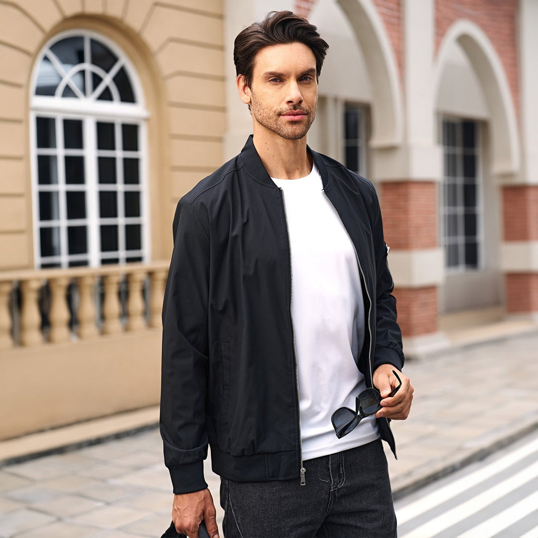 A stack of folded men's bomber jackets, various colors, showcasing range of options
