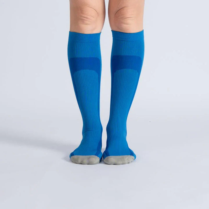 Unisex blue gray gentle compression socks, close-up of fabric texture and ribbed cuff for leg support.