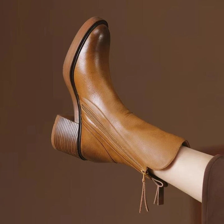 Pair of black leather ankle boots for women, featuring a practical zip closure and sturdy heel