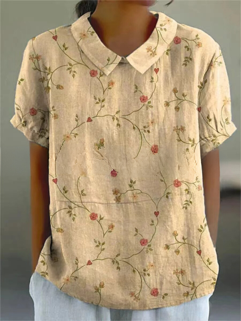 Spring fashion women's blouse, elegantly embroidered with floral vines, featuring a stylish Peter Pan collar.