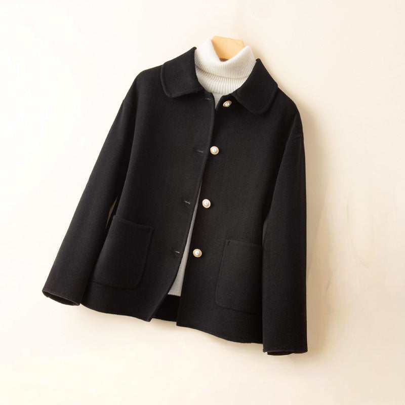 Detail of the fine cashmere knit texture on a women's button jacket, premium quality knitwear