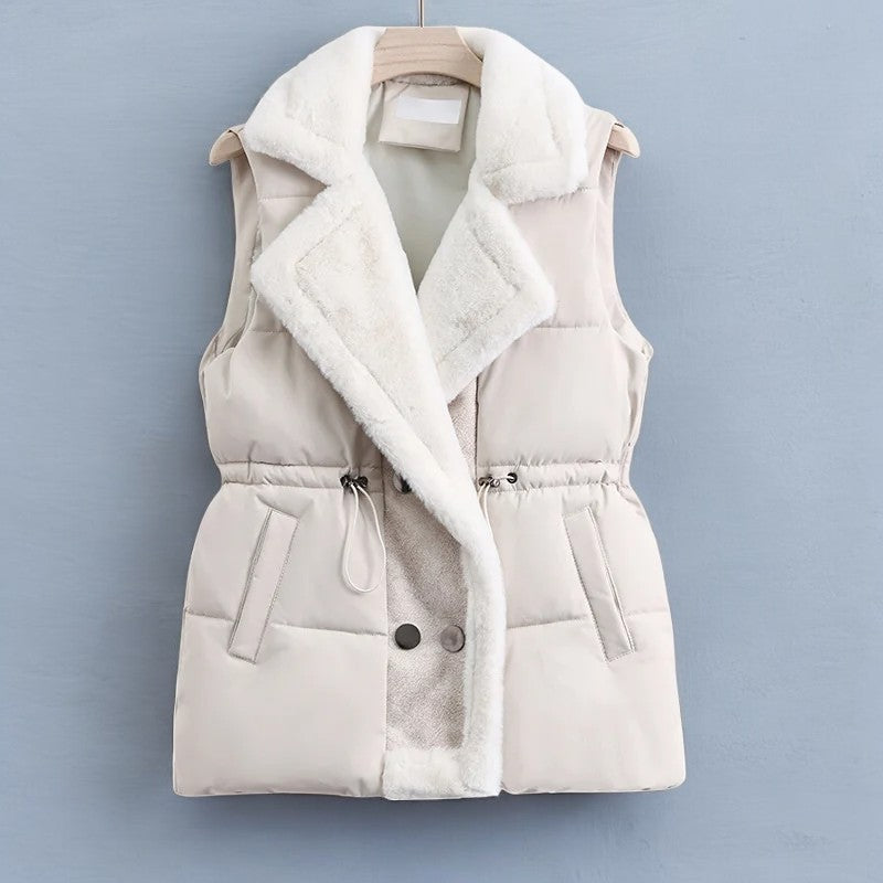 Model wearing a women's puffer vest, layered over a sweater, and ready for winter