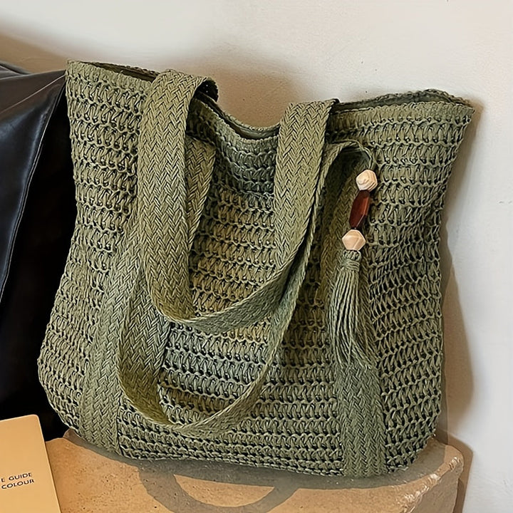 Stylish straw beach tote for women, featuring intricate woven design and decorative fringe tassels.