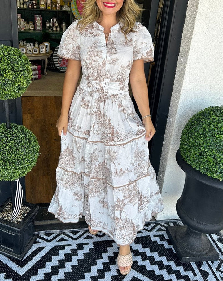 Women's toile print maxi dress with puff sleeves, showcases vintage charm with a scenic motif and fitted silhouette.